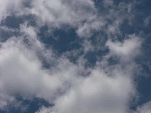 Blue sky with small white cloud forming abstract shape 写真素材