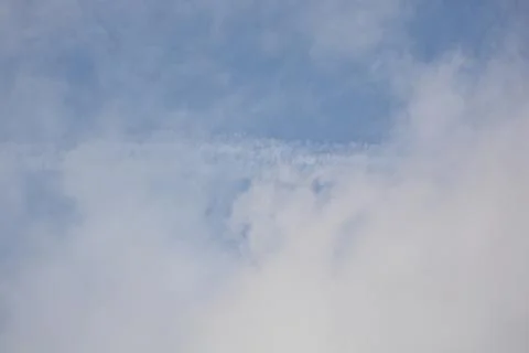 Blue sky with soft clouds and light vapor line Foto stock