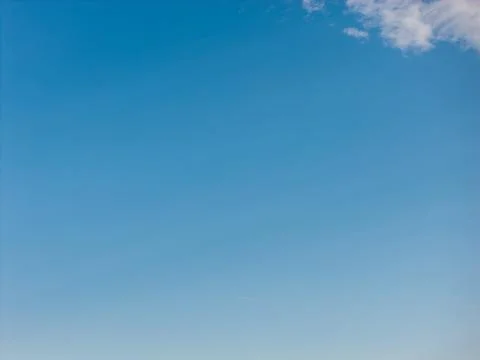 Blue sky with a soft gradient and a fluffy white cloud in the upper right corner Stock Photos