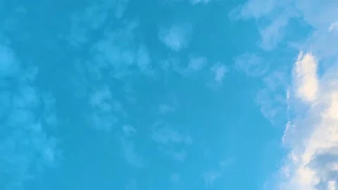 Blue sky with soft white clouds glowing in warm sunlight background Video stock 345152231