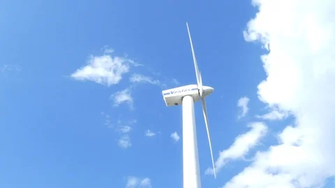 Blue sky with some clouds and rotating wind turbine Stock Footage 106493154