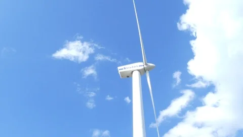 Blue sky with some clouds and rotating wind turbine - slow motion Stock Footage 106498841