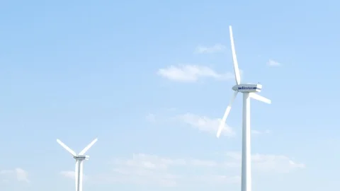 Blue sky with some clouds and two rotating wind turbines Stock Footage 106500680