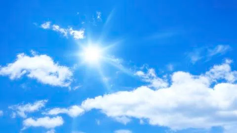 Blue sky with some clouds and the sun Stock Photos