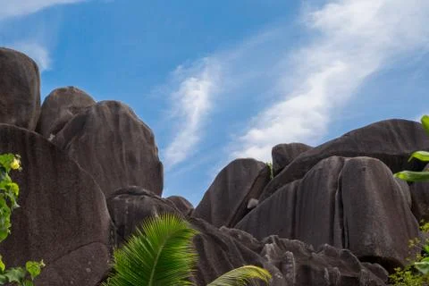 Blue sky with some clouds and big stones in front Stock Photos
