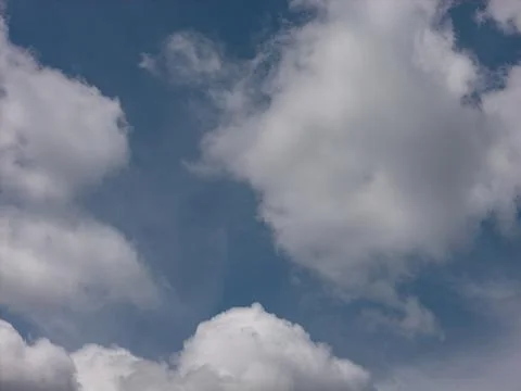 Blue sky with sparse white clouds creating emptiness 스톡 사진