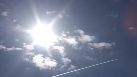 Blue sky, sun and sunbeams, small clouds - plane with contrails - time lapse Stock Footage 153890306