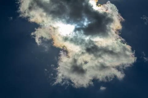 A blue sky with the sun behind the clouds 库存照片