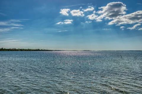 Blue sky with sun rays peeping through the clouds at sea convey eternal freedom Foto stock