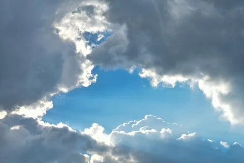 Blue sky surrounded by gray clouds. Place for an inscription. Stock Photos