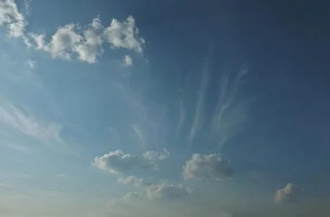 Blue sky with thin cirrus clouds fanning out from cumulus clouds. Fotos Stock
