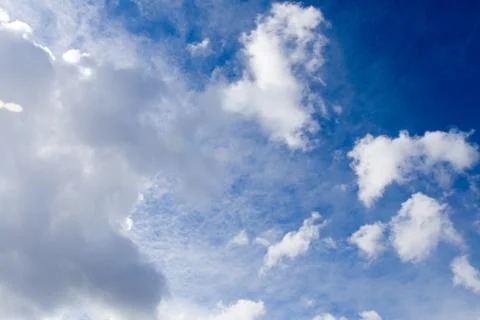Blue sky with torn white clouds Stock Photos
