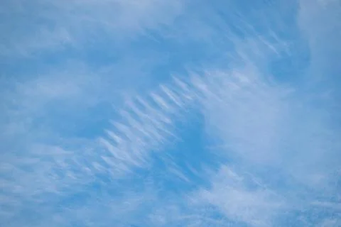 Blue sky with unusually shaped clouds Stock Photos