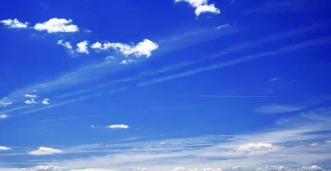 Blue sky with various clouds and a faint contrail, perfect for backgrounds Stock Photos