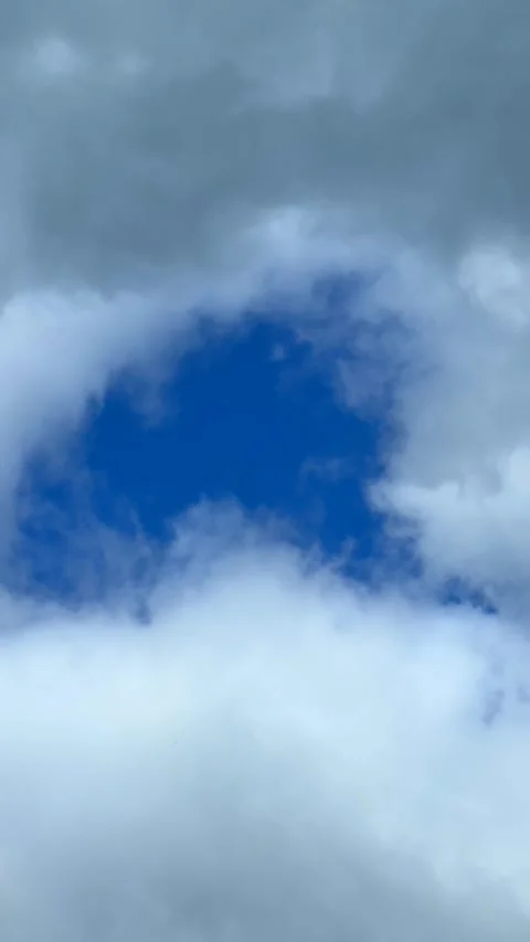 Blue sky view through dramatic fluffy clouds on sunny day Stock Footage 311982065