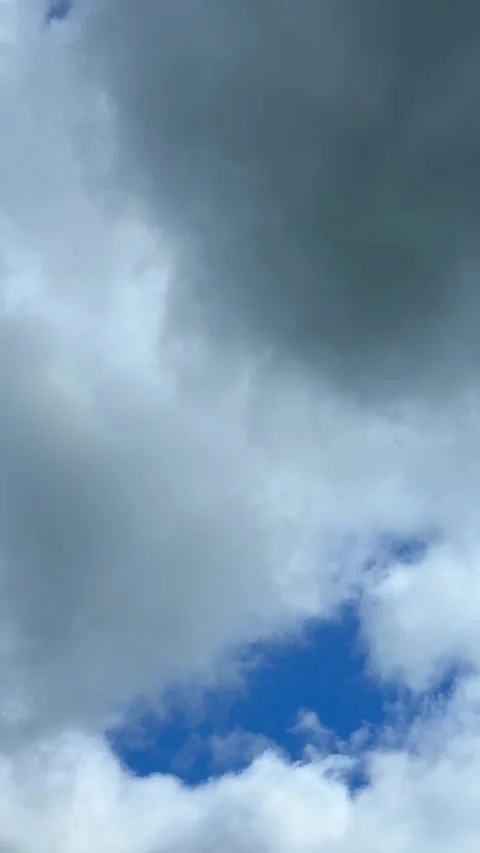 Blue sky view through dramatic fluffy clouds on sunny day Stock Footage 311982165