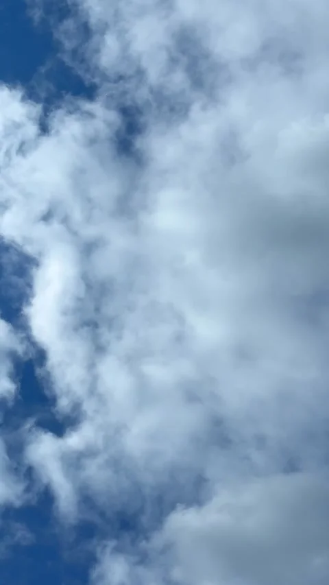 Blue sky view through dramatic fluffy clouds on sunny day Stock Footage 311982275