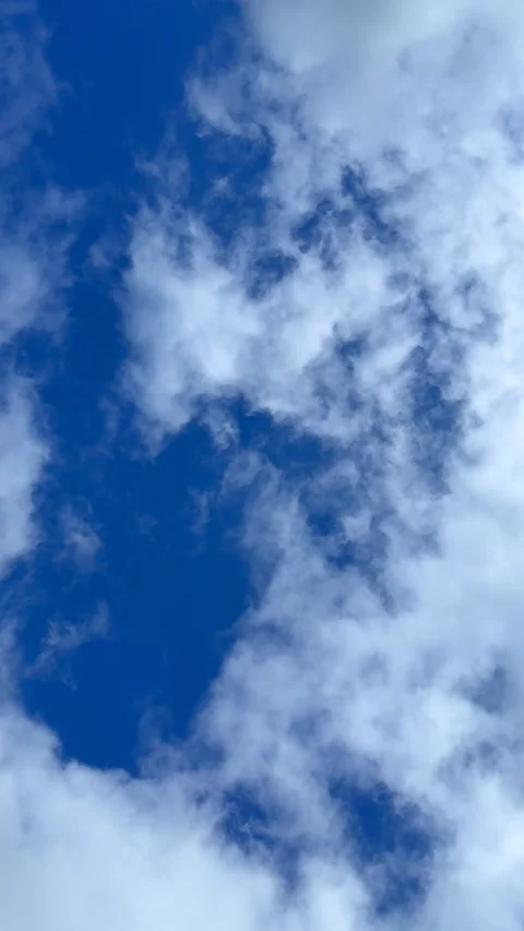 Blue sky view through dramatic fluffy clouds on sunny day Stock Footage 311982282