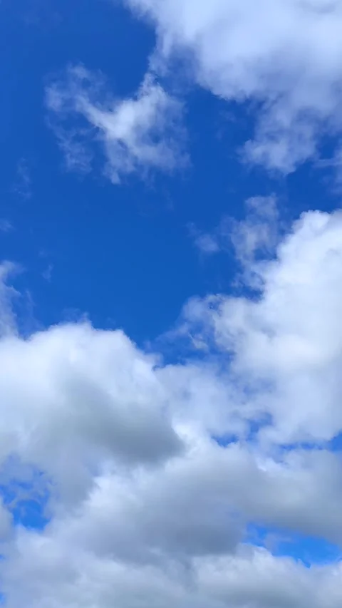 Blue sky view through dramatic fluffy clouds on sunny day Stock Footage 311982371