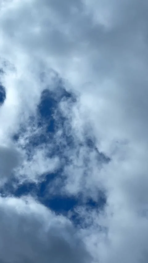 Blue sky view through dramatic fluffy clouds on sunny day Stock Footage 311982399