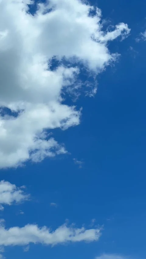 Blue sky view through dramatic fluffy clouds on sunny day Stock Footage 311982424