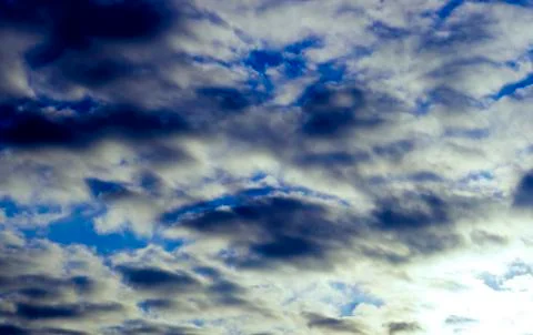 A blue sky is visible through the clouds in the early morning at sunrise. Stock Photos