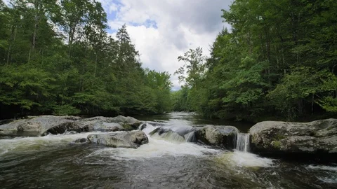 Blue Sky White Clouds and Mountain Creek Panning Tilting Shot Stock Footage 100392822