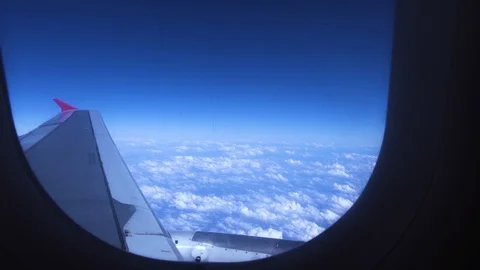 Blue sky, white clouds and wing view from window flying passenger airplane Video stock 105051069