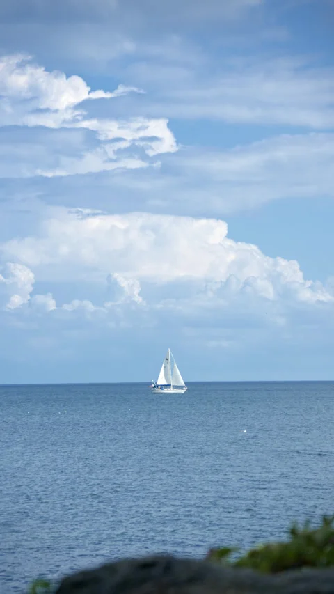 Blue sky, white clouds, and sailboats in the distance 스톡 동영상 343794438