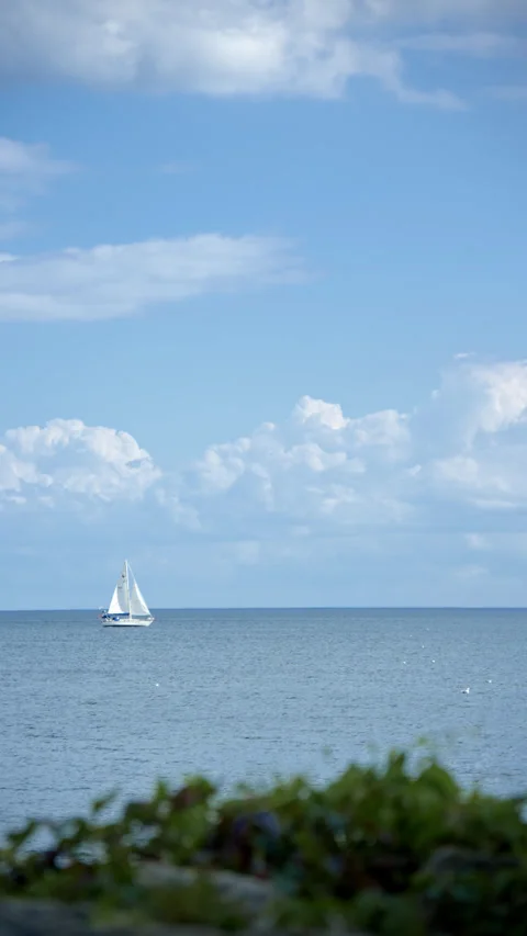 Blue sky, white clouds, and sailboats in the distance 스톡 동영상 343794442