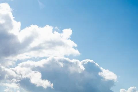 Blue sky with white clouds and skylights on a bright sunny day, soft focus Stock Photos