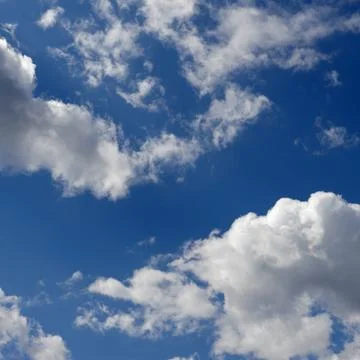 Blue sky with white clouds backlit by sunlight Stock Photos
