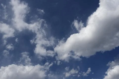 Blue sky with white clouds backlit by sunlight Foto stock