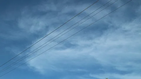 Blue sky, white clouds, black electric wires Stock Footage 159440046