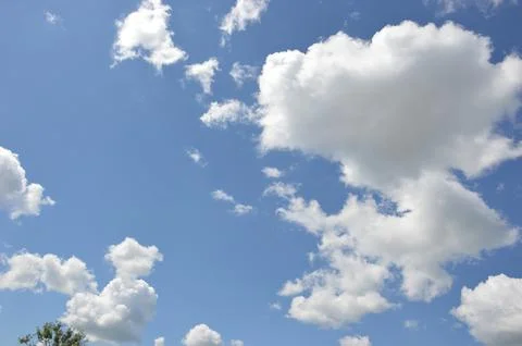 Blue sky with white clouds on a clear day. Natural natural background. Stock Photos