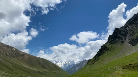 Blue sky with white clouds. Green rocky slopes of the Elbrus region Stock Footage 135326024
