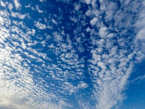 A blue sky with white clouds in the middle of it Stock Photos