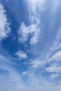 Blue sky white clouds nature background. Vertical cloudscape Stock Photos