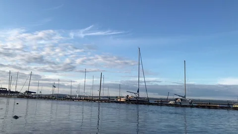 Blue sky, white clouds over blue sea. Wood pier Stock Footage 80356518