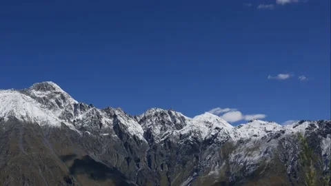 Blue sky white clouds over snow mountains. Puffy fluffy white clouds. Cumulus Stock Footage 163922348