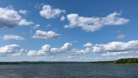 Blue sky with white clouds over the water of a large lake. Moving the camera Stock Footage 296804266