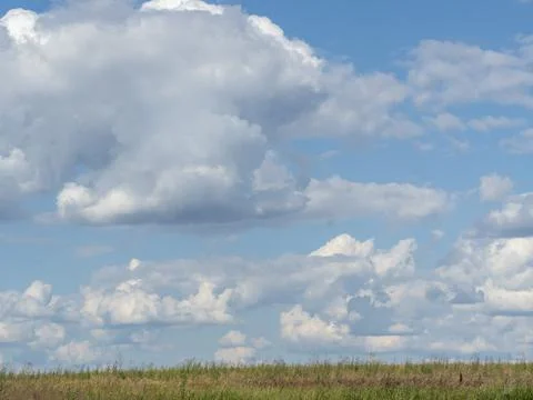 Blue sky with white clouds over the field. Texture, template Stock Photos