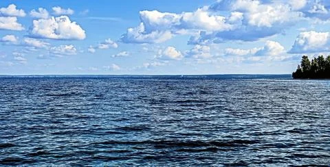 Blue sky with white clouds over lake Stock Photos