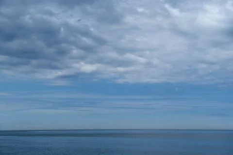 Blue sky with white clouds over calm sea horizon, beautiful seascape Stock Photos