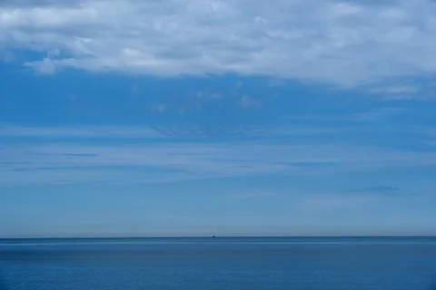 Blue sky with white clouds over calm sea horizon, beautiful seascape Stock Photos