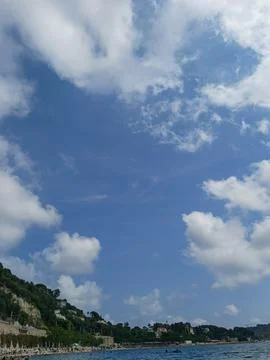 Blue sky with white clouds over coastline in villefranche sur mer, france 库存照片