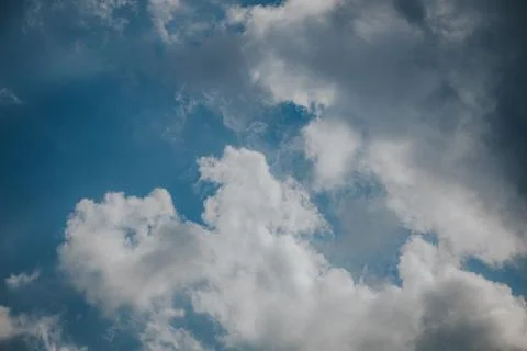 Blue sky with white clouds scattered across the frame, showcasing a serene .. 스톡 사진