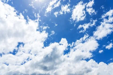 Blue sky with white clouds under sunshine Stock Photos