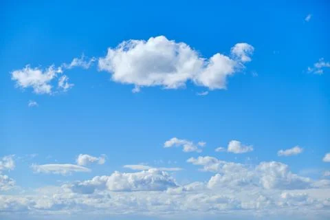 Blue sky with white cumulus clouds. Bright sunny day with cloudy sky Stock Photos