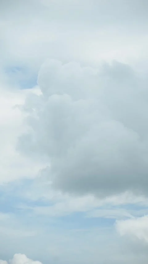 Blue sky with white fluffy clouds, vertical time lapse video Stock Footage 310947568